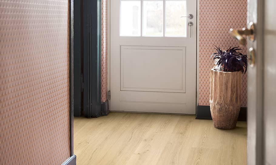 hallway with pink walls and a beige laminate floor